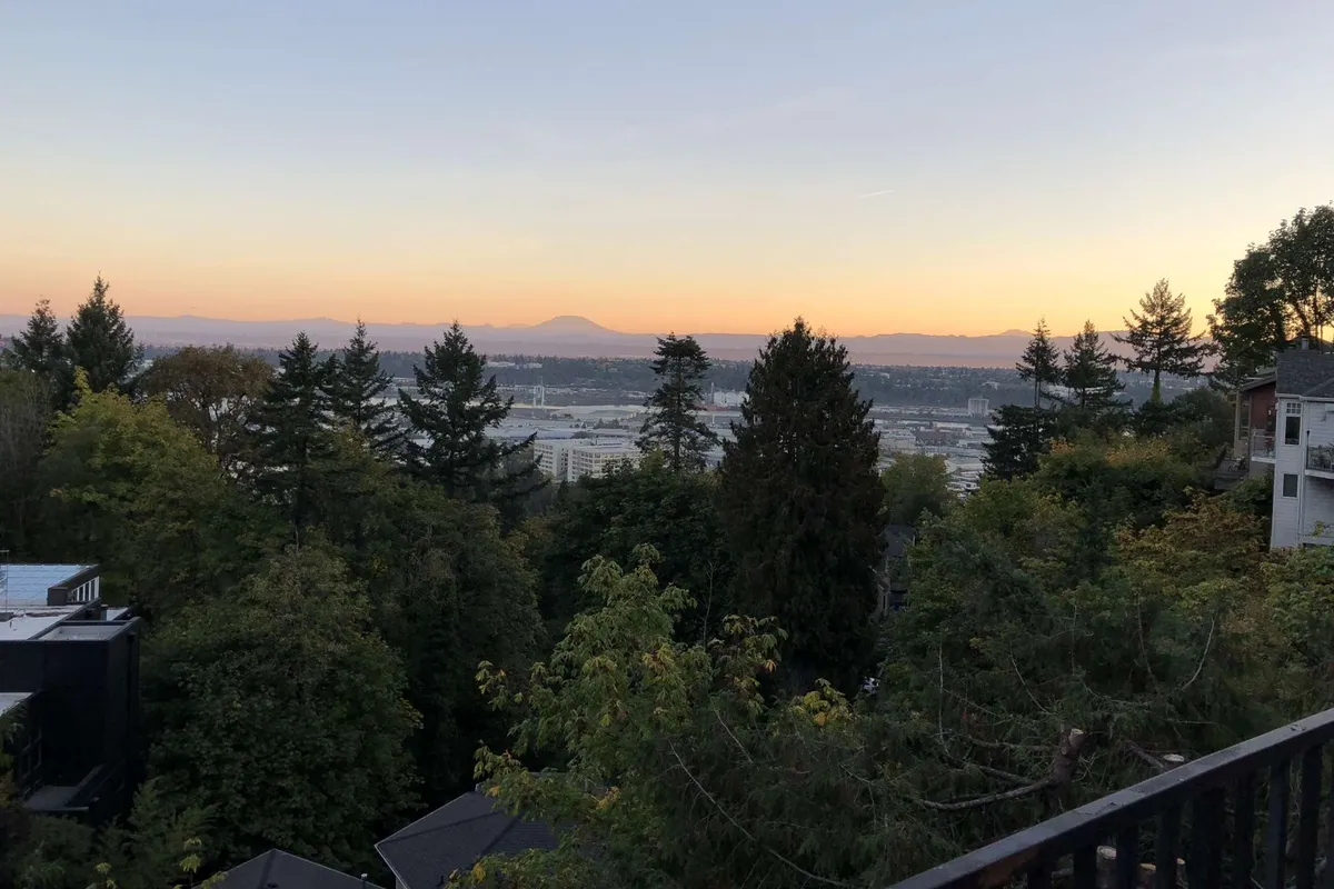 A serene vantage highlighting distant mountains, vibrant greenery, the Portland skyline, and warm sunset hues. The image captures moments of relaxation, nature immersion, and the enjoyment of scenic outdoor spaces that are mere steps away from home.